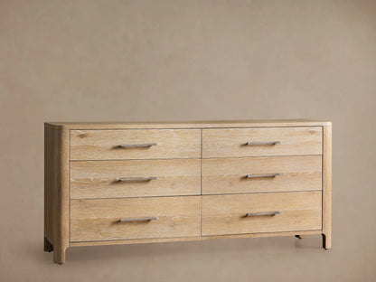 Calista Six-Drawer Dresser, light oak wood veneer. Angled view of top left, one drawer open showing gray interior, silver bar pulls.