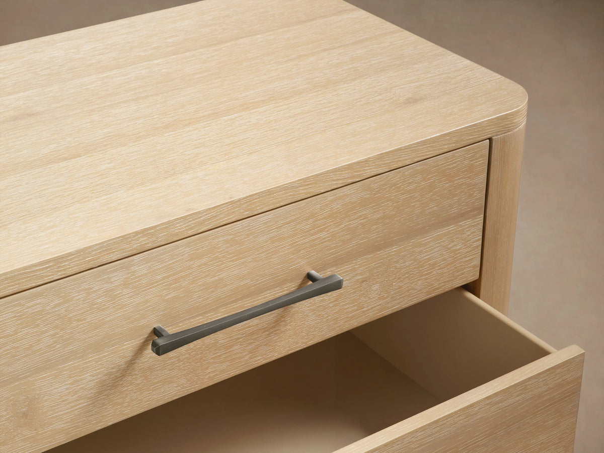 Calista Nine-Drawer Dresser in light oak, modern, with silver bar handles. Two right drawers are slightly open.