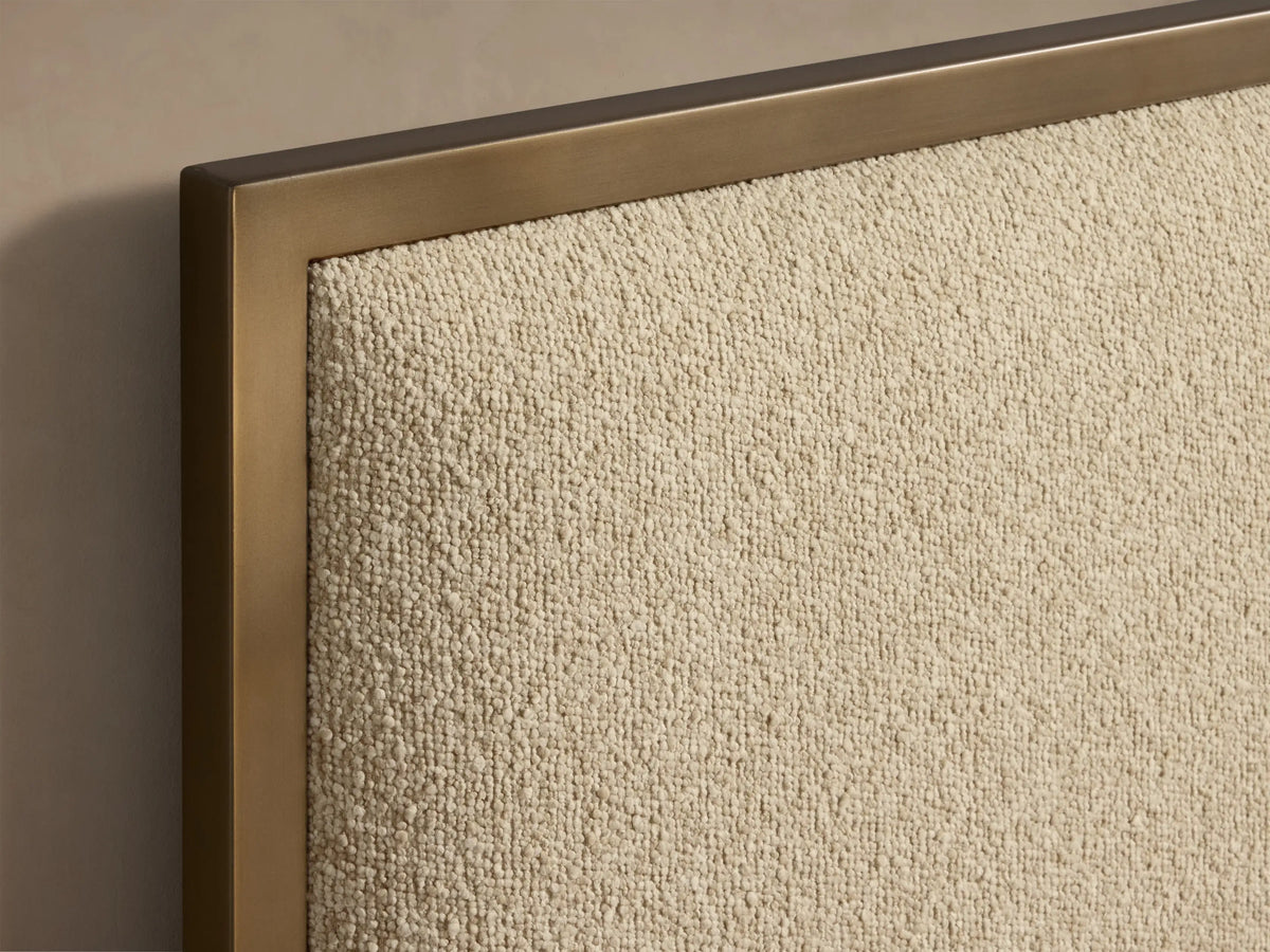 Front view of the Chamberlain Bed, featuring a beige upholstered headboard and base with bronze frame, dressed in white ribbed bedding.