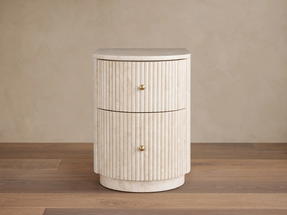Clementine Reeded Stone Nightstand with light reeded stone, rounded front, two drawers, brass knobs.