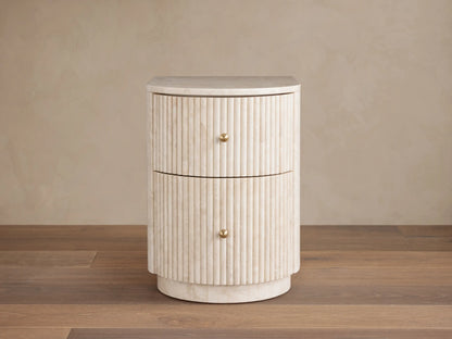Clementine Reeded Stone Nightstand with light reeded stone, rounded front, two drawers, brass knobs.