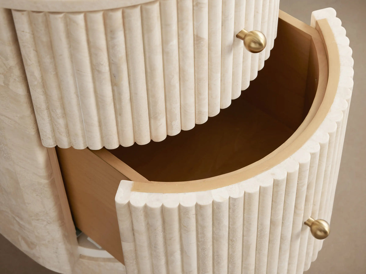 Clementine Reeded Stone Nightstand with light reeded stone, rounded front, two drawers, brass knobs.