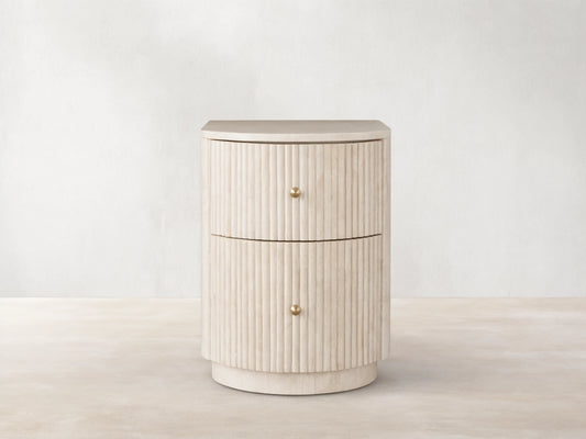 Clementine Reeded Stone Nightstand with light reeded stone, rounded front, two drawers, brass knobs.