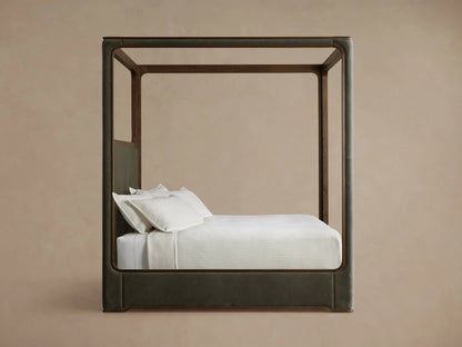 Conley Canopy Bed detail: dark oak wood frame with grain, showing a rounded corner where it meets dark olive-green fabric.