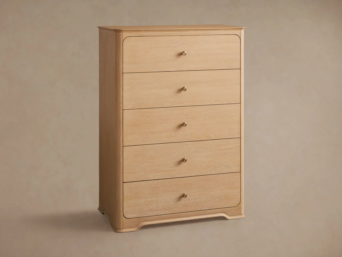 Conley Five-Drawer Dresser: Light oak wood dresser with five drawers, rounded edges, and small champagne brass knob pulls.