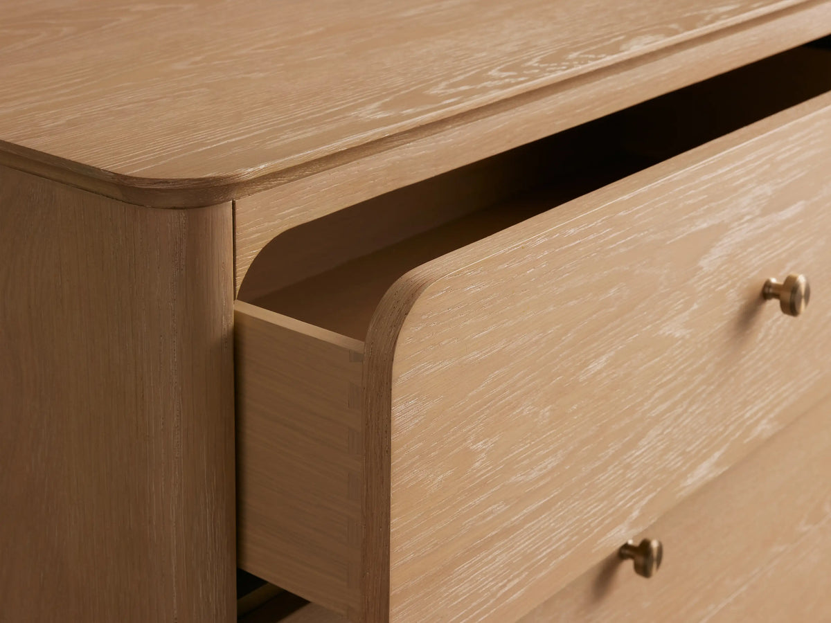 Conley Five-Drawer Dresser: light oak wood with rounded edges, five drawers each with a small brass knob, on a plain background.
