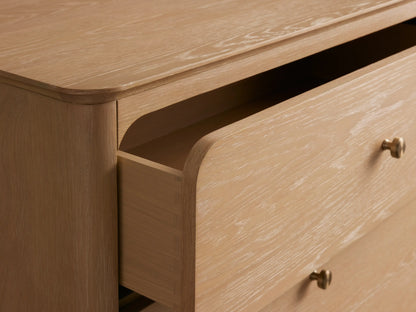 Conley Five-Drawer Dresser: light oak wood with rounded edges, five drawers each with a small brass knob, on a plain background.
