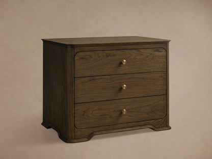 Right side view of a dark brown oak Conley Nightstand with three drawers, champagne brass pulls, and graceful curvature.