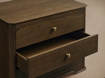 Dark brown oak Conley Nightstand, front view, with three drawers, round champagne brass pulls, and graceful curved edges and base.
