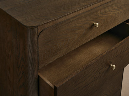 Conley Five-Drawer Dresser, dark brown oak, 5 stacked drawers with curved fronts and small champagne brass pulls, wood grain.
