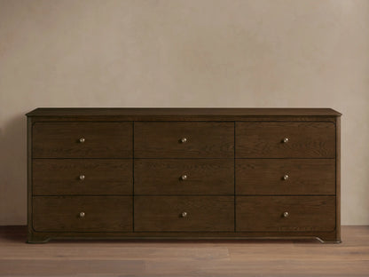 Conley Nine-Drawer Dresser: Dark brown oak wood, 9 drawers with visible grain and champagne brass pulls, against a beige wall.