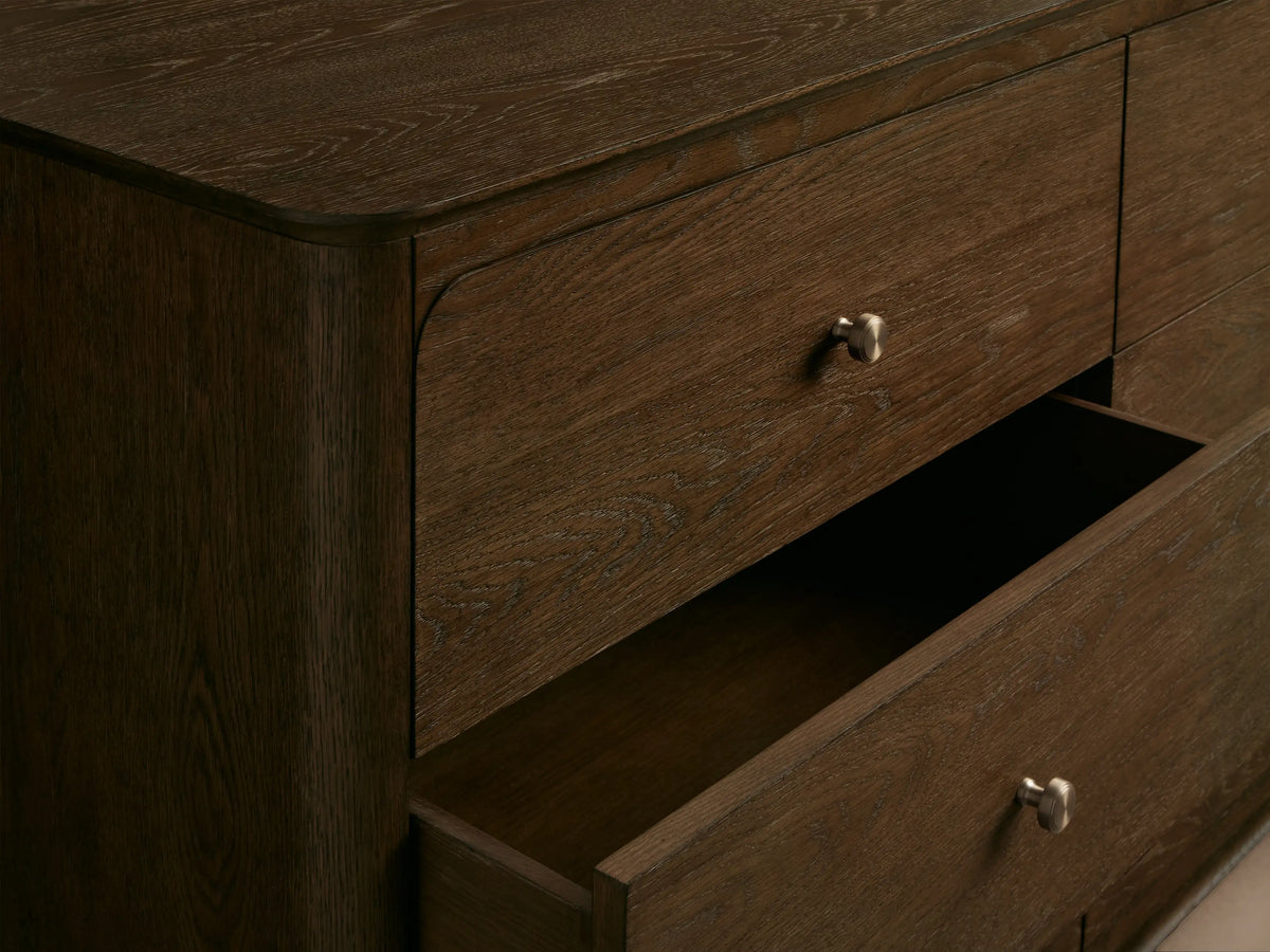 Conley Nine-Drawer Dresser, dark brown oak, 9 drawers with round champagne brass pulls, curved top & side edges.
