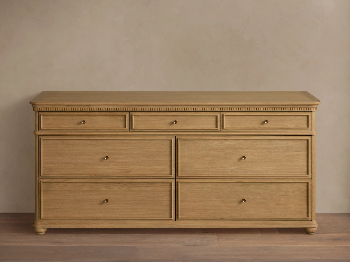 Carlisle Seven-Drawer Dresser, light oak wood, 3 small drawers over 4 large, with antique brass pulls and fluted trim.