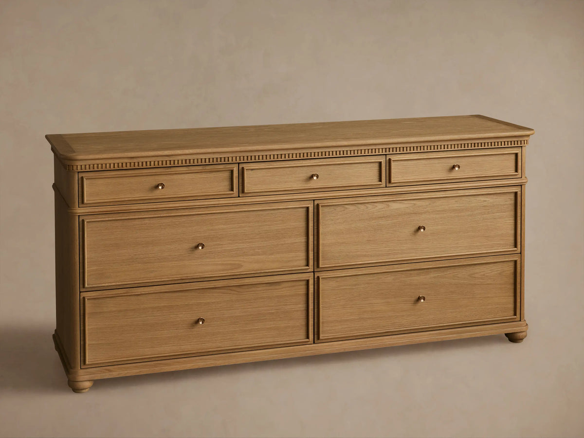 Carlisle Seven-Drawer Dresser, light oak wood, 3 small drawers over 4 large, with antique brass pulls and fluted trim.