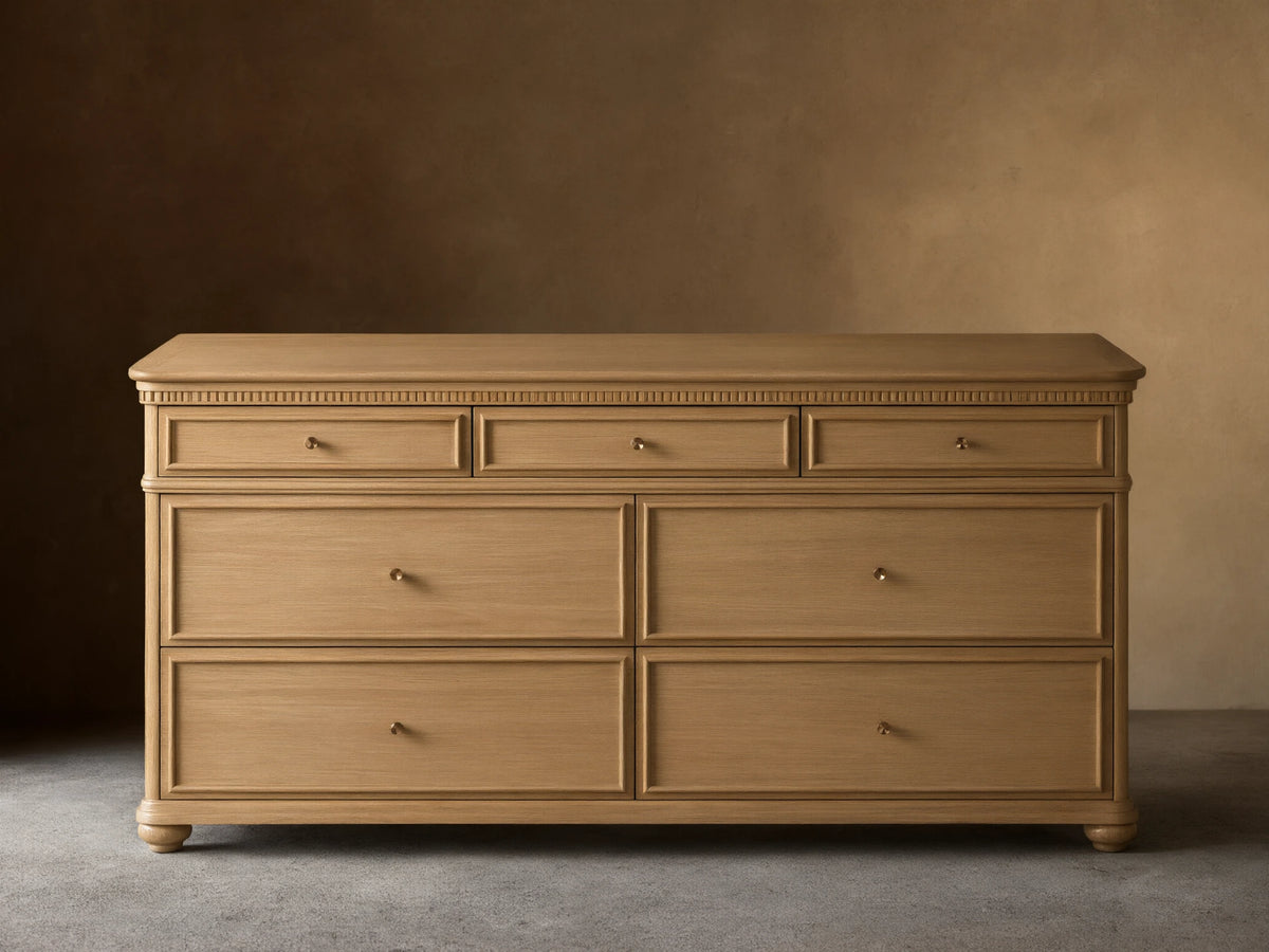 Carlisle Seven-Drawer Dresser, light oak wood, 3 small drawers over 4 large, with antique brass pulls and fluted trim.