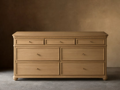 Carlisle Seven-Drawer Dresser, light oak wood, 3 small drawers over 4 large, with antique brass pulls and fluted trim.