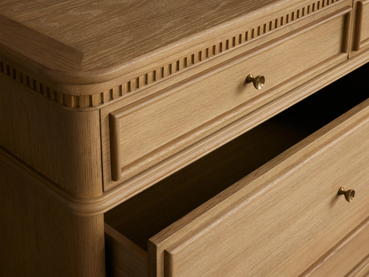 Carlisle Seven-Drawer Dresser, light natural oak wood finish with antique brass pulls, decorative molding, and rounded feet.