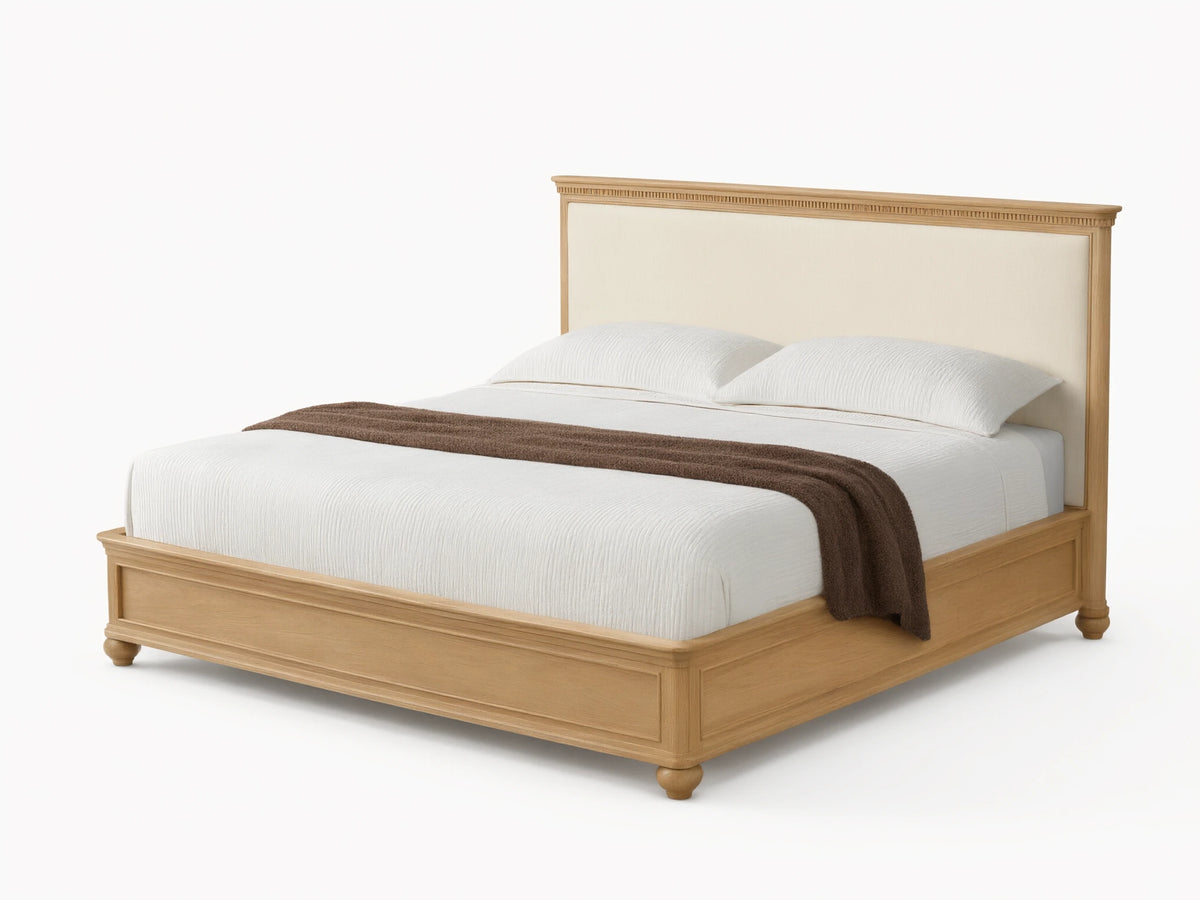 Carlisle Bed: Light oak frame, cream upholstered headboard, white striped bedding, brown throw, on wood floor.