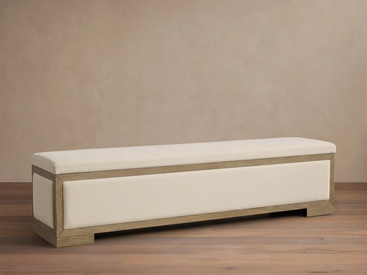 Front view of the Darien Storage Bench, featuring a light oak wood frame and cream upholstered top and front panel.