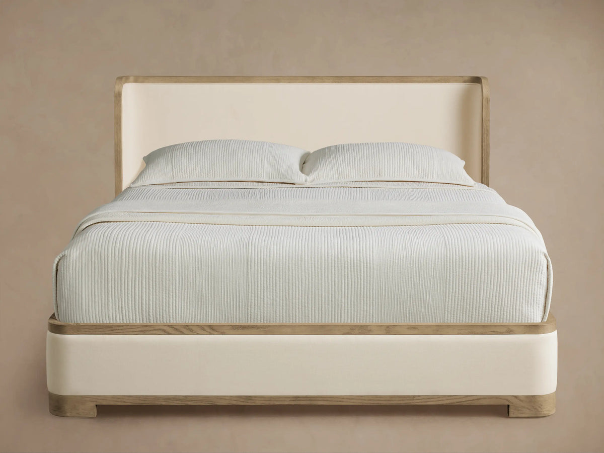 Darien Curved Shelter Bed with low footboard, cream upholstered panels, light oak wood trim, and a curved headboard.