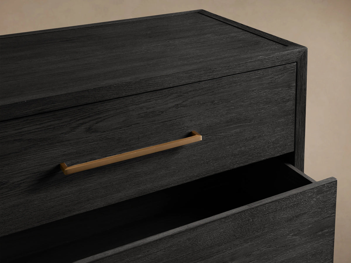 Darwyn Five-Drawer Dresser in dark oak finish showing open top drawer with brass pull handle, against a neutral background.