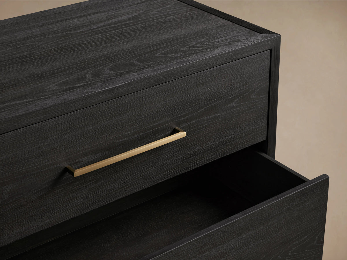 Darwyn Six-Drawer Dresser in dark oak finish features brass drawer pulls, partially open top drawer, showcasing wood grain.