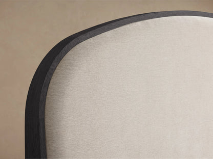 Danny Bed with ebony finished oak frame, upholstered beige headboard, and white bedding, viewed from the front.