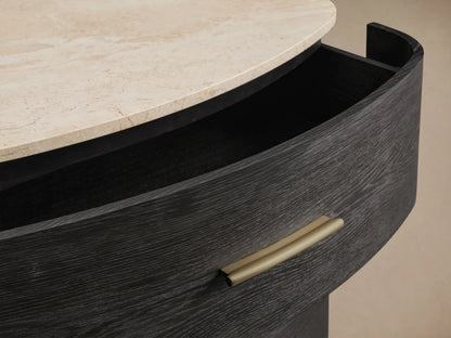 Danny Five-Drawer Dresser showing black oak wood with brass pull, cream marble top, and partially open drawer.