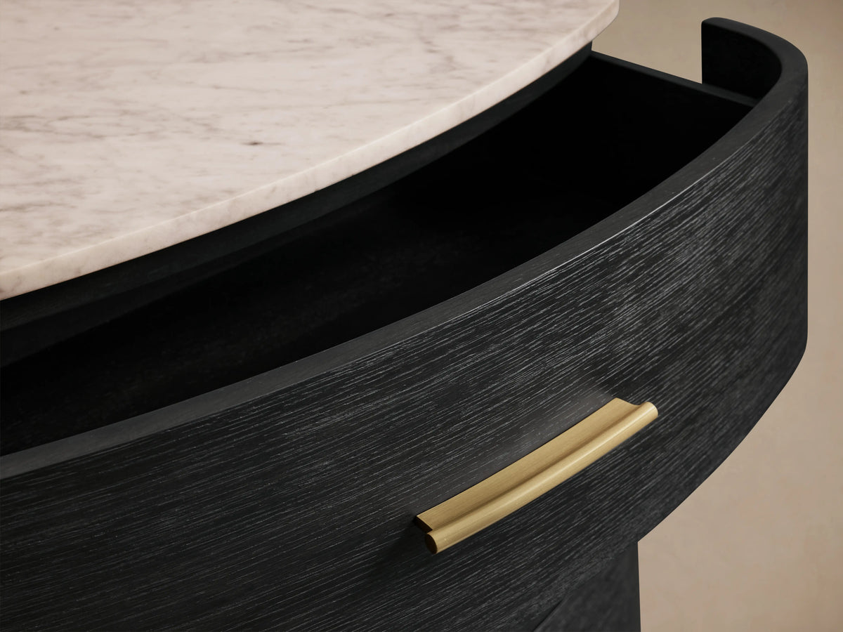 Danny Six-Drawer Dresser with ebony finish, curved black oak wood, brass handles, cream marble top, two open drawers.