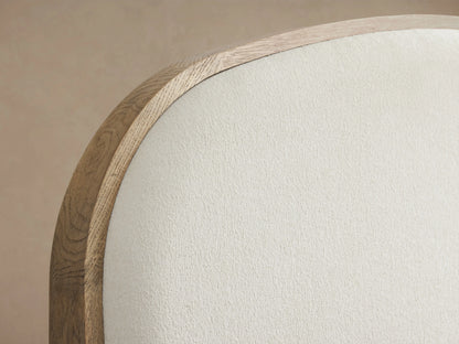 Danny Bed in oak wood with a fawn finish, featuring an upholstered headboard with white bedding, viewed from side angle.