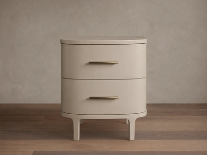Danny Nightstand in fumo: light beige, rounded nightstand with two drawers, horizontal brass pulls, on short splayed legs.