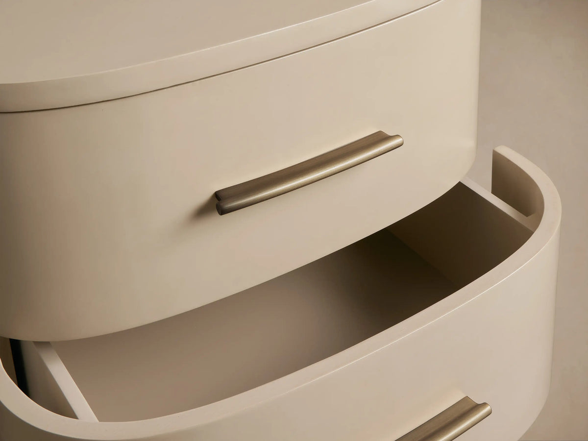 Danny Nightstand in fumo, two rounded drawers with brass pulls, on a wood floor against a neutral textured wall.