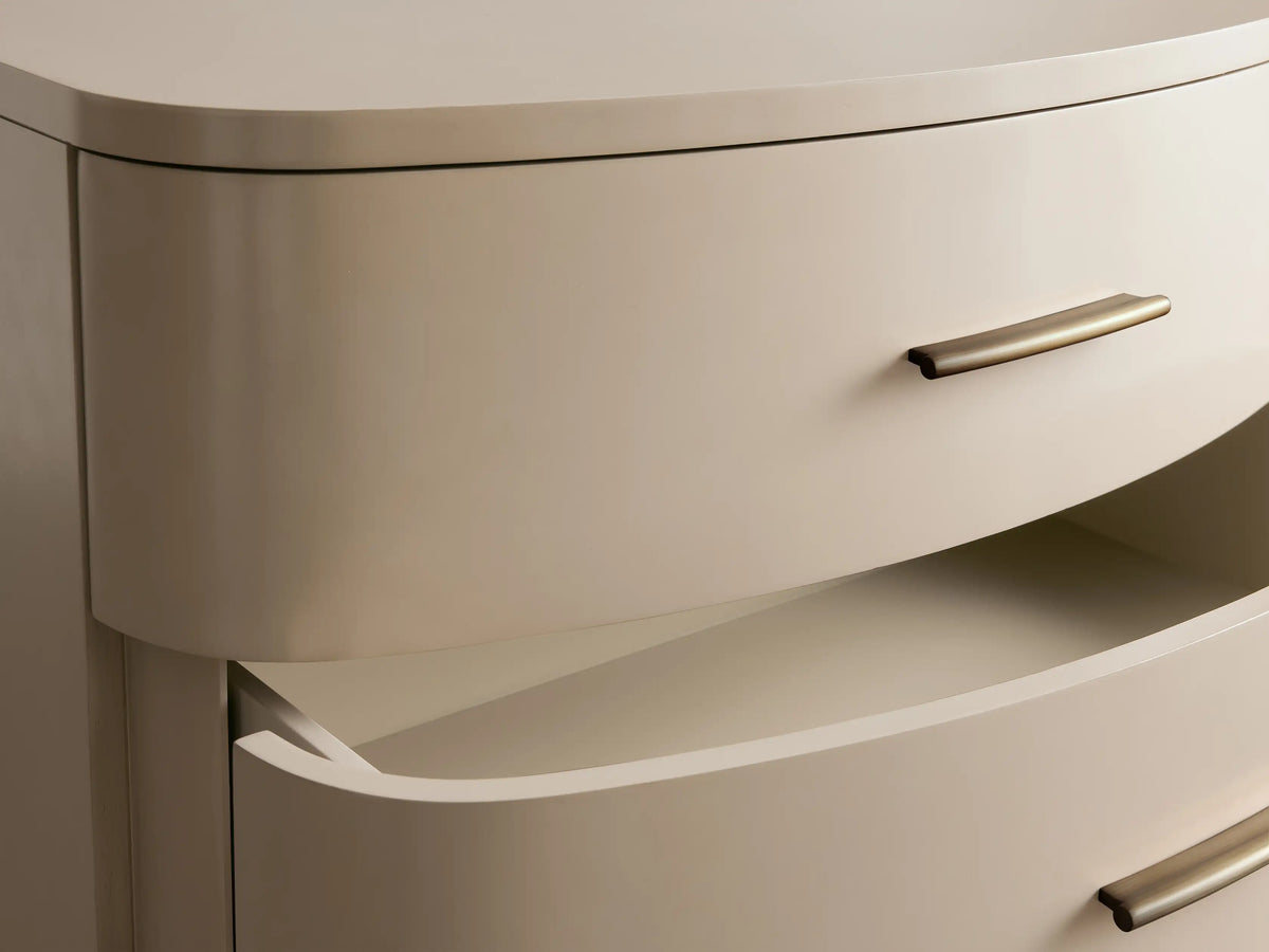 Danny Five-Drawer Dresser in Fumo, curved front, with 5 light greyish-beige drawers, horizontal brass pulls, and short legs.