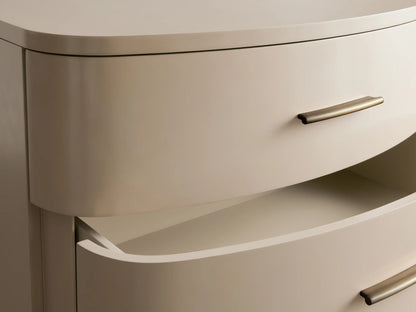 Danny Five-Drawer Dresser in Fumo, curved front, with 5 light greyish-beige drawers, horizontal brass pulls, and short legs.
