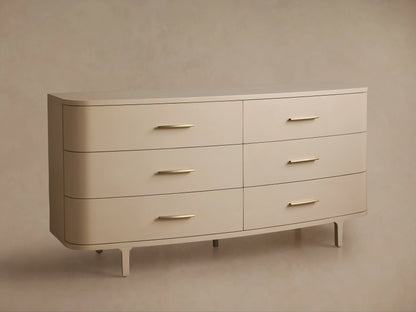Danny Six-Drawer Dresser in Fumo. Light cream-colored dresser with six drawers, brass pulls, rounded edges, and tapered legs.