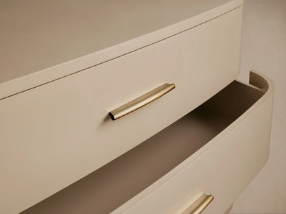 Fumo Danny Six-Drawer Dresser. Light beige, curved front, six drawers with horizontal brass pulls, on splayed legs.