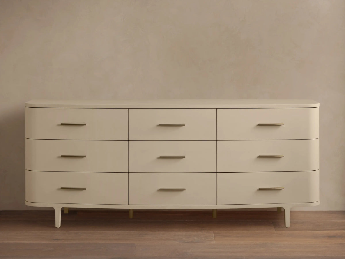 Danny Nine-Drawer Dresser in fumo, a light beige, with rounded corners, 9 drawers, and horizontal brass pulls.