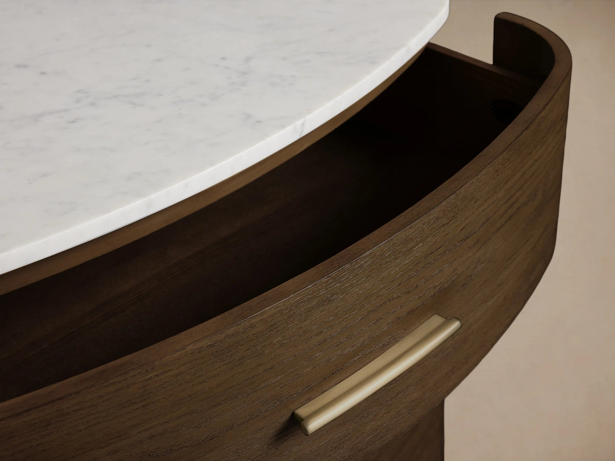 Danny Five-Drawer Dresser: dark oak, curved front, white marble top, brass pulls. Two bottom drawers open, angled.