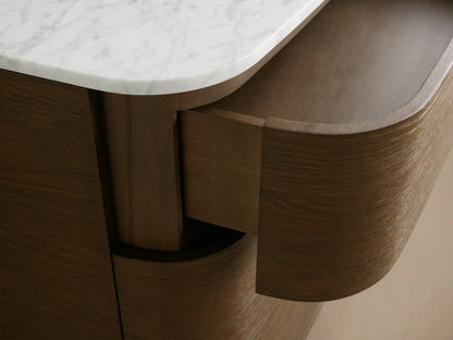 Danny Six-Drawer Dresser, dark oak wood with curved front, white marble top, and six brass-handled drawers.