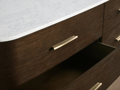 Danny Nine-Drawer Dresser; modern dark oak wood with a white marble top, nine drawers with sleek brass pulls, curved ends, on legs.
