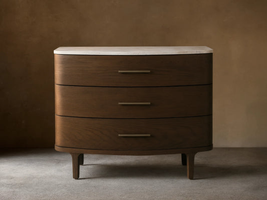 Danny Three-Drawer Chest: dark brown oak with rounded edges, white marble top, three horizontal brass handles, on wood floor.