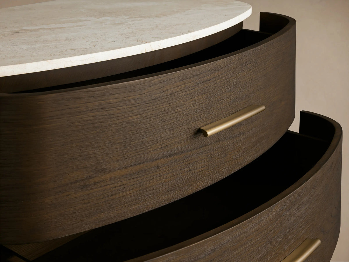 Danny Five-Drawer Dresser: dark oak wood, rounded front, white marble top, five drawers with brass pulls, on tapered legs.