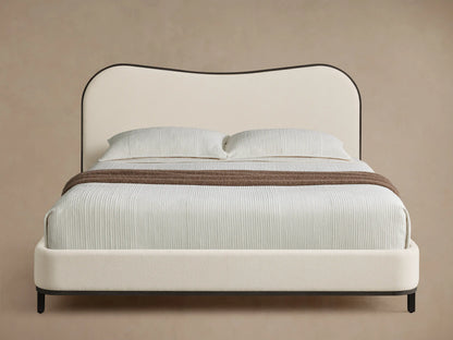 Front view of the Danny Camelback Bed with a brown tree-patterned headboard, light beige base, and white bedding.