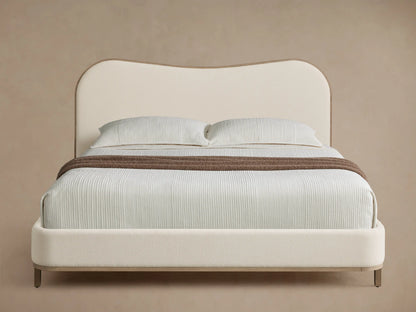 Front view of the Danny Camelback Bed, featuring a brown patterned camelback headboard and beige upholstered frame.