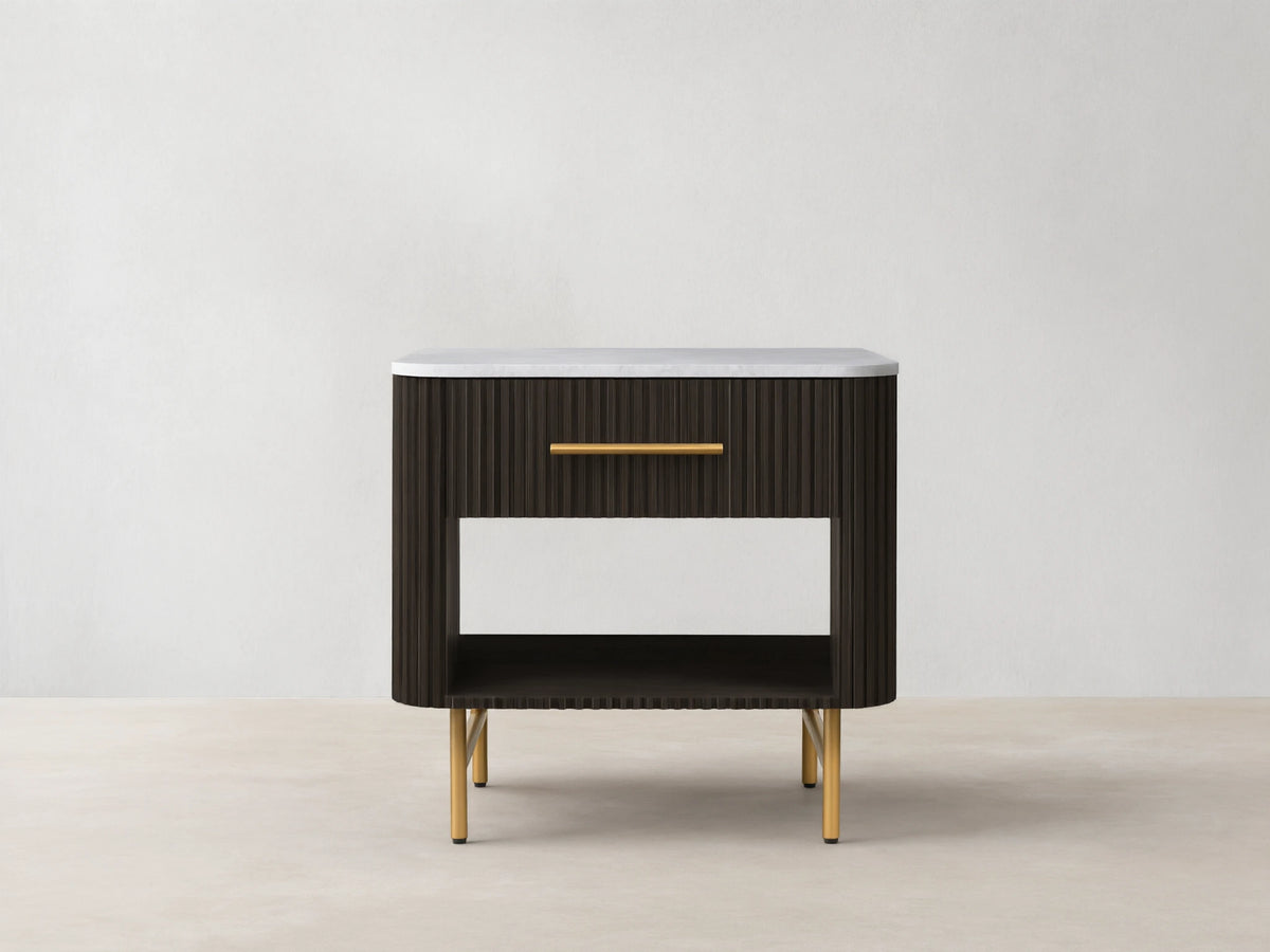 Finnley Open Nightstand with a marble top, brass-finished handle, dark ribbed body, open shelf, and brass legs on a wooden floor.