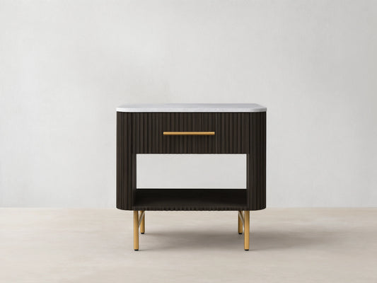 Finnley Open Nightstand with a marble top, brass-finished handle, dark ribbed body, open shelf, and brass legs on a wooden floor.