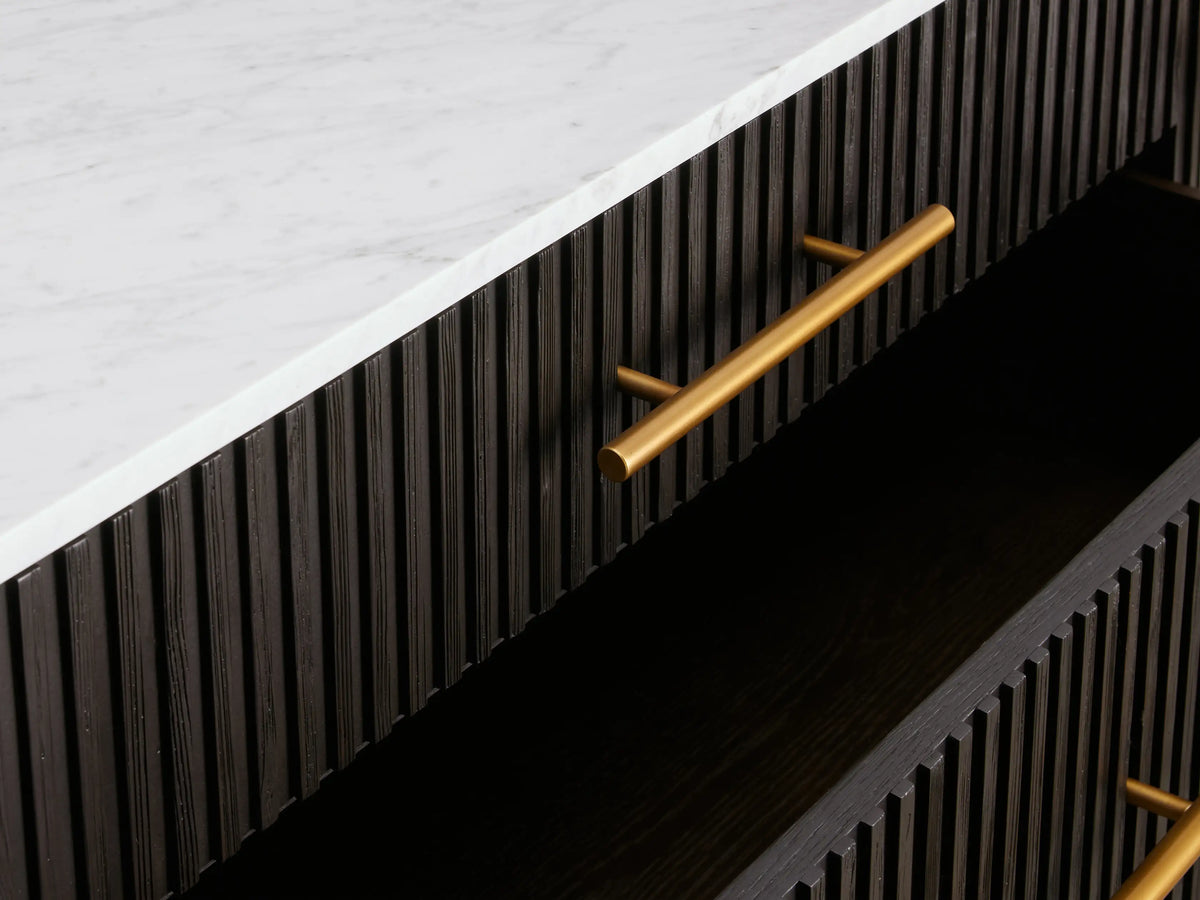 Finnley Five-Drawer Dresser: Dark wood dresser with reeding, five gold bar pulls, dark stone top, and gold angled legs.