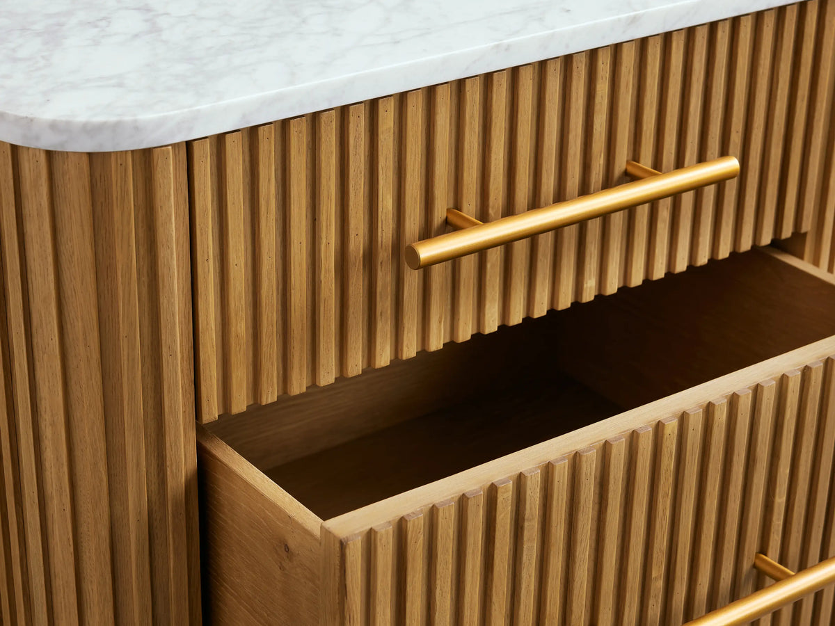 Wooden nightstand with two drawers, featuring vertical slats and gold metal handles and legs, topped with a white surface.