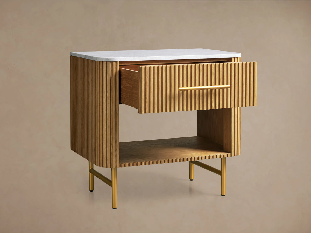Finnley Open Nightstand with ribbed Honey finish, featuring white stone top, brass handle, open shelf, and four yellow legs on wooden floor.
