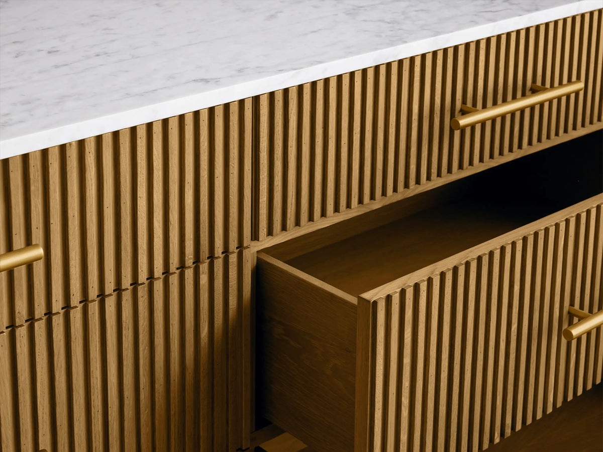 Finnley 6 drawer dresser with honey ribbed wooden base and smooth white Carrara marble top, featuring gold handles.
